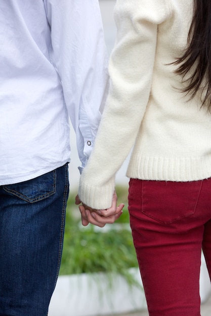 Foto novio y novia tomados de la mano al aire libre