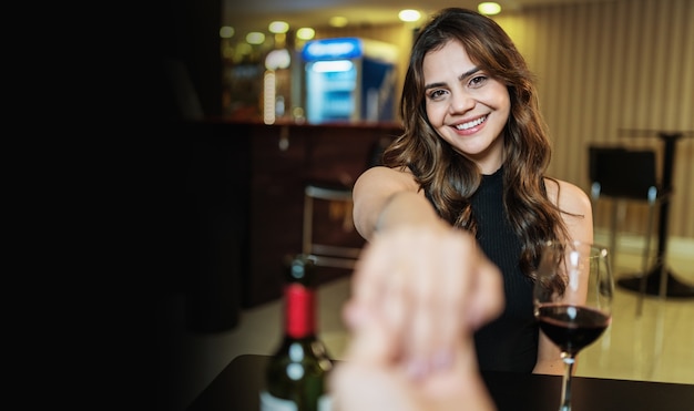 Novio pidiendo la mano de su novia con un anillo de compromiso en un restaurante