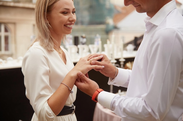 El novio le pone el anillo de bodas a la novia.