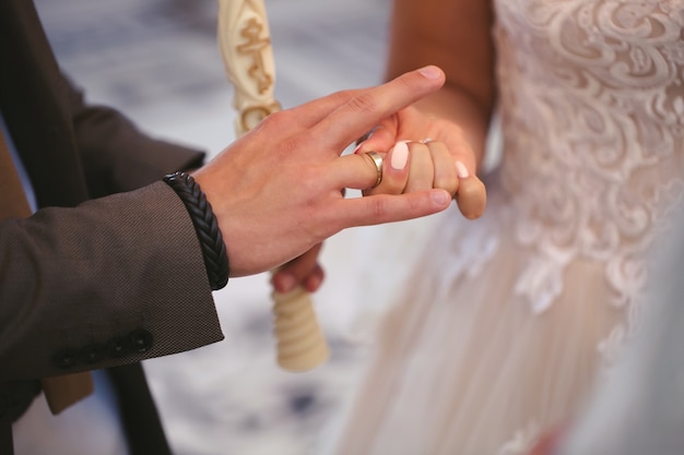 El novio pone el anillo en el dedo de la novia.