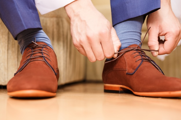 Novio poniendo sus zapatos de boda.