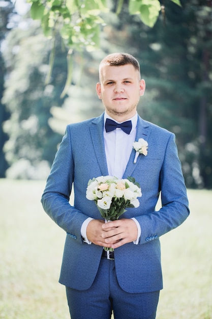 Novio con un ramo de flores en sus manos esperando a la novia, primer plano