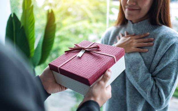 Un novio sorprende y le da a su novia una caja de regalo.