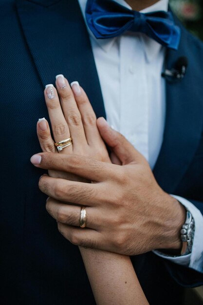 El novio sostiene la mano de la novia Foto