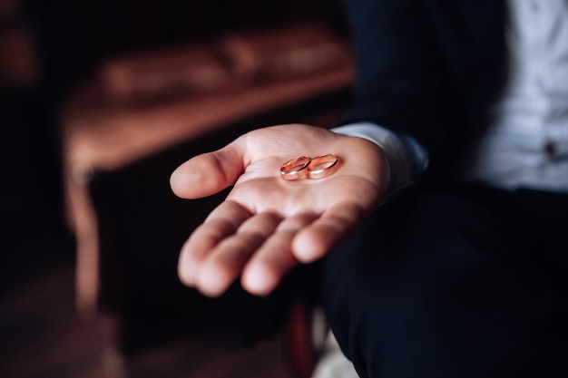 el novio tiene anillos de boda en la mano