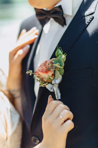 El novio tiene un ramo de boda en sus manos.