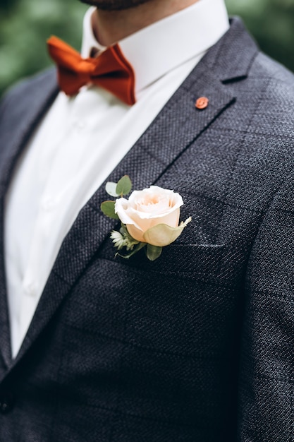 El novio con traje gris y se levantó en la solapa de la chaqueta.