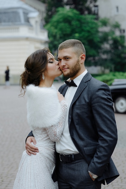 El novio con traje gris y la novia con vestido gris se miran