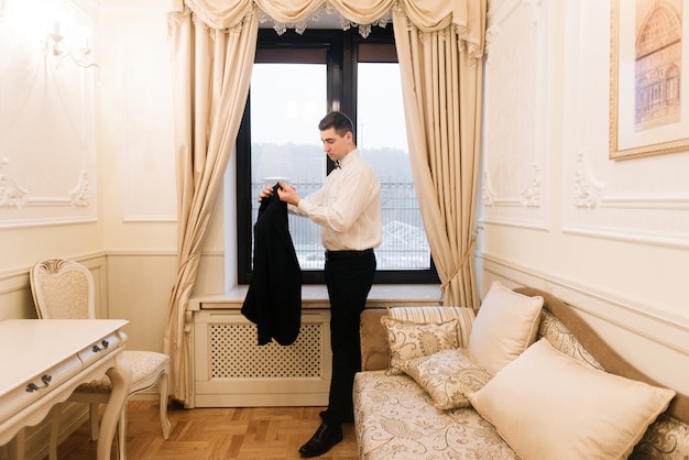 Novio vistiendo un traje y preparándose para una boda