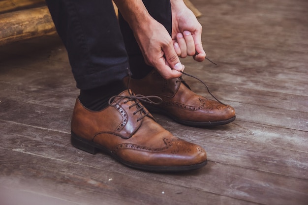 Un novio y zapatos de boda. El novio lleva zapatos al aire libre. Retrato masculino de chico guapo.