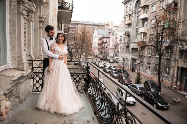 Los novios se abrazan en el balcón. Pareja abrazándose en el balcón y disfruta de la vida