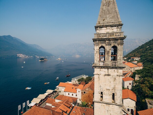 Los novios se abrazan en la ventana de la antigua torre en el casco antiguo de perast