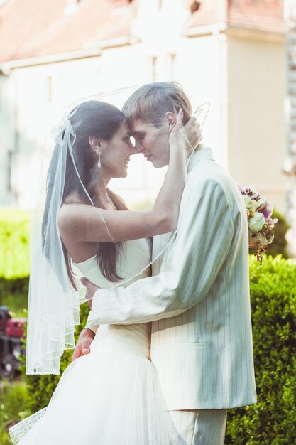 Novios se besan y sonríen al aire libre