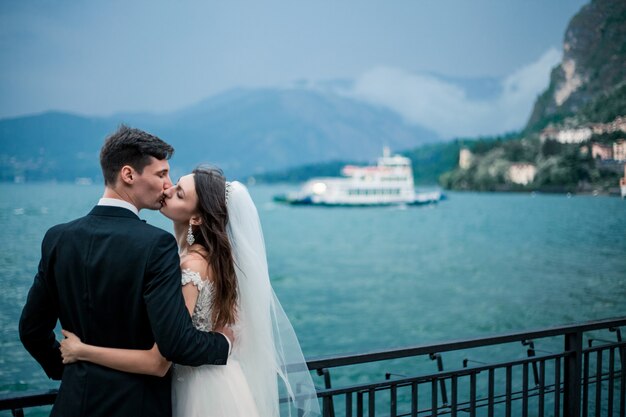 Novios besándose en el fondo de un lago y montañas