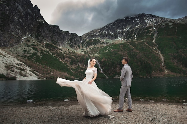 Novios caminando cerca del lago en las montañas Tatra en Polonia, Morskie Oko