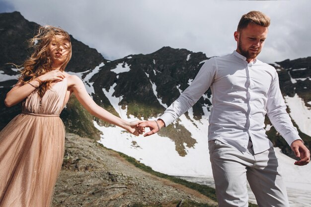 Novios caminando por las montañas con impresionantes vistas