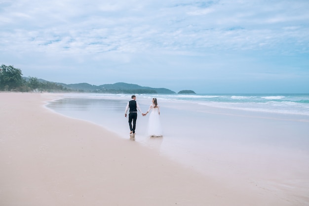 Novios caminando por la playa