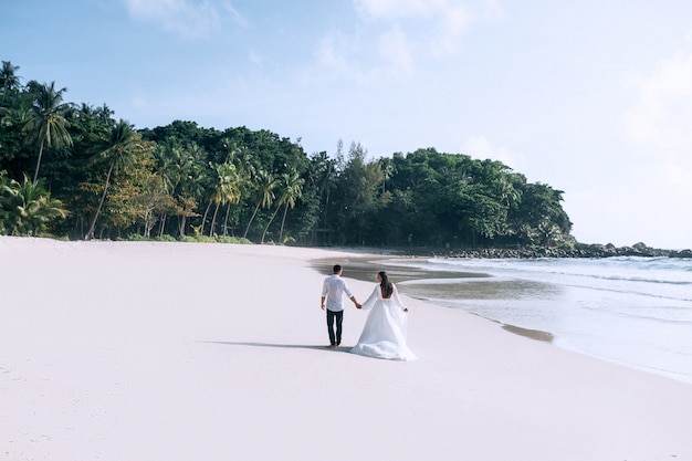 Novios caminando por la playa