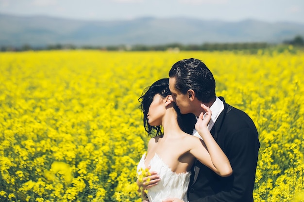 Novios en campo de flores amarillas