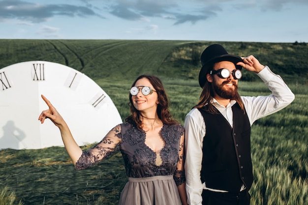 Foto novios elegantes caminando y posando en campo verde