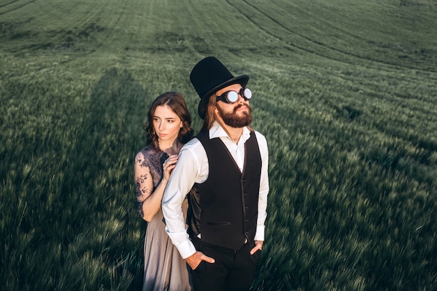 Foto novios elegantes caminando y posando en campo verde