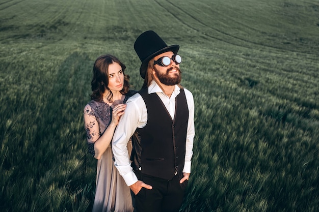 Foto novios elegantes caminando y posando en campo verde