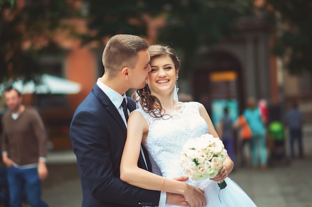 Novios elegantes cerca de la antigua casa vintage