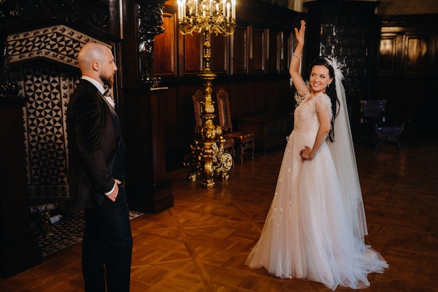 Novios elegantes en el interior del antiguo castillo de la ciudad de Nesvizh.