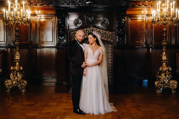 Novios elegantes en el interior del antiguo castillo de la ciudad de Nesvizh.