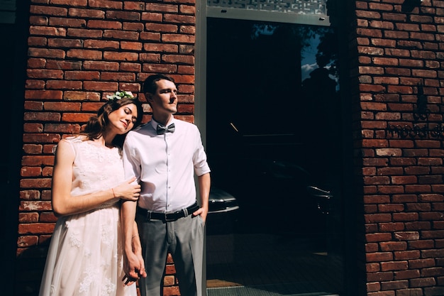 Novios elegantes posando juntos al aire libre en el día de la boda