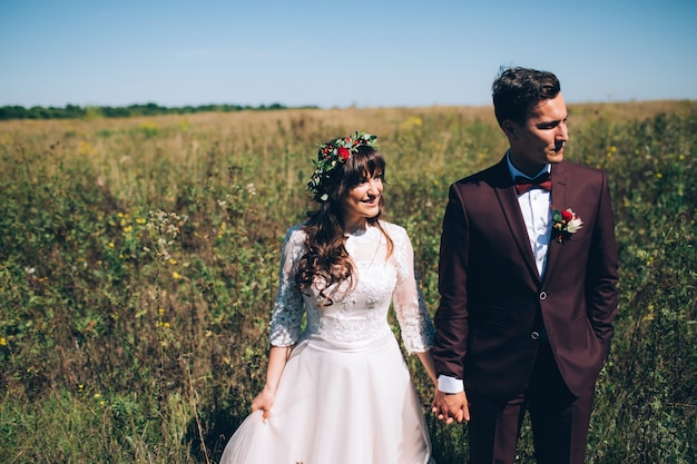 Novios elegantes posando juntos al aire libre en el día de la boda