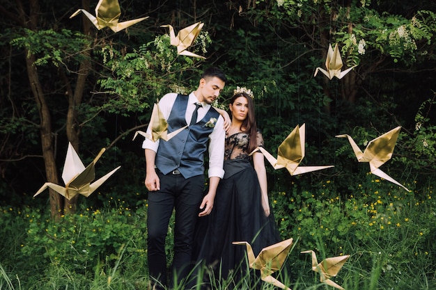 Novios elegantes posando juntos al aire libre en el día de la boda