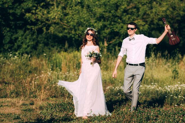 Novios elegantes posando juntos al aire libre en el día de la boda