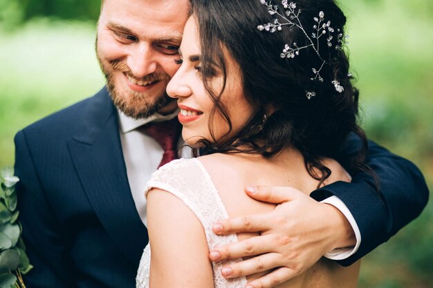 Foto novios elegantes posando juntos al aire libre en el día de la boda