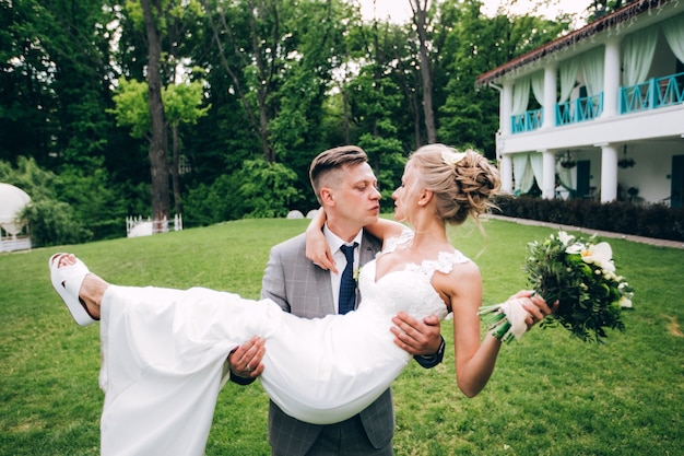 Foto novios elegantes posando juntos al aire libre en el día de la boda