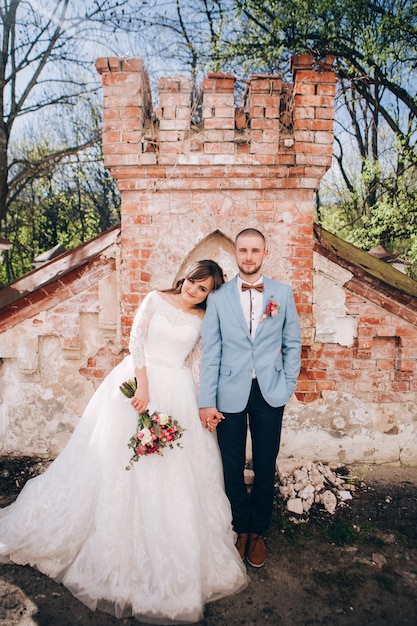 Foto novios elegantes posando juntos al aire libre en el día de la boda