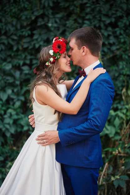 Novios en el fondo de la pared de vegetación