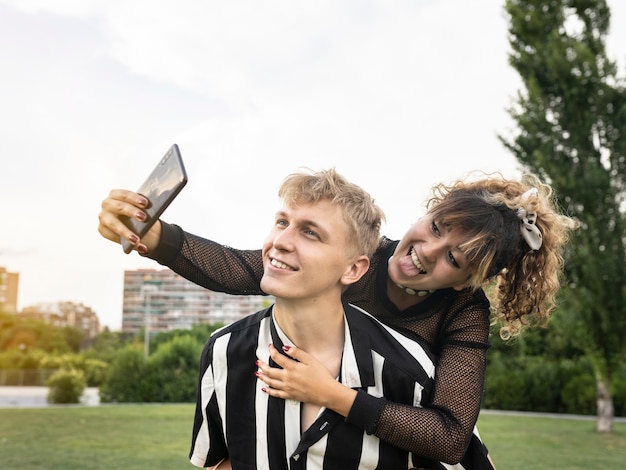 novios se miran, toman fotos, felices. en un parque