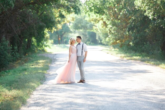 Novios en la naturaleza en día de verano. la novia y el novio abrazándose en la boda.