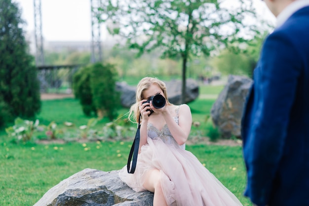 Novios en una sesión de fotos. La novia dispara al novio en la cámara.