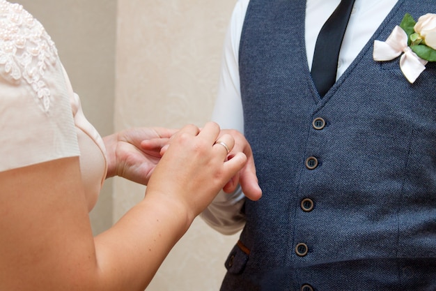 Los novios se visten con anillos de boda en la ceremonia de registro de matrimonio.