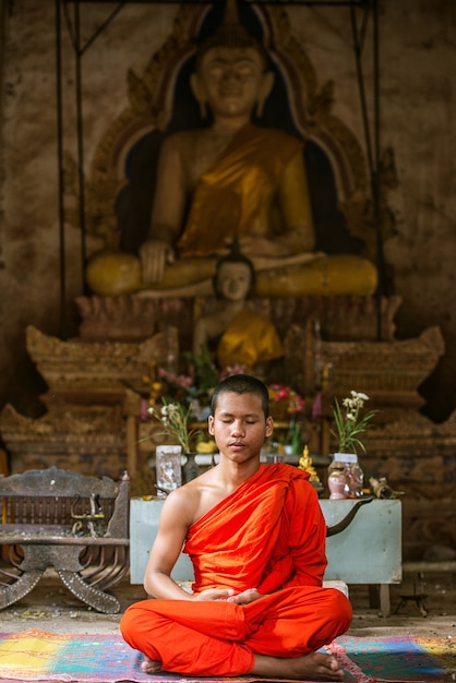 Novizenmönchmeditation vor Buddha-Statue.