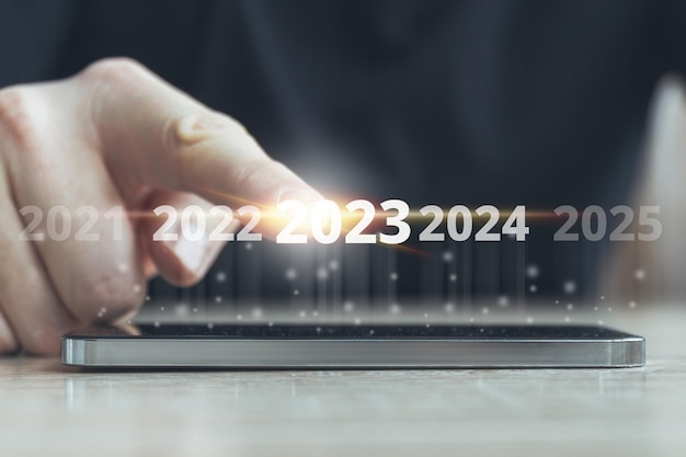 Novo conceito de 2023 dedo tocando a tela abstrata com mudança de horário