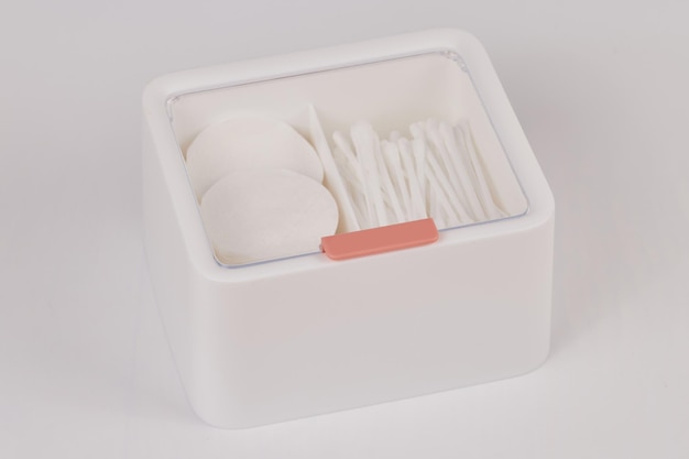 Novo organizador de plástico branco para produtos cosméticos cheios de palitos de algodão e almofadas isoladas em fundo branco