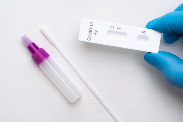 Foto novo teste antigênico de coronavírus e kit para diagnóstico rápido em médico mão em luvas de borracha no