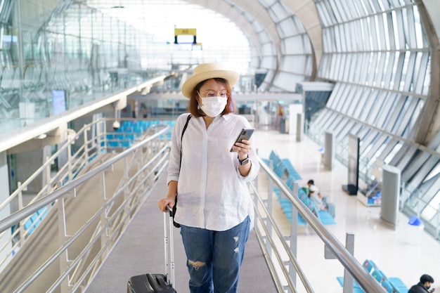 Novo turista normal usando máscara facial está viajando no aeroporto nova viagem de estilo de vida após covid 19