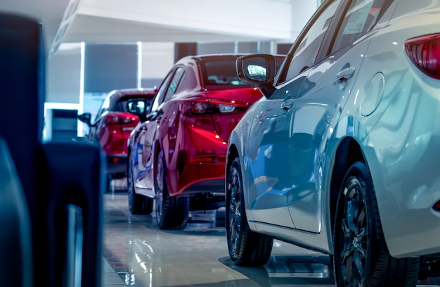 Foto novos carros vermelhos e brancos de luxo estacionados no moderno showroom