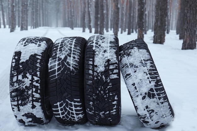 Foto novos pneus de inverno na neve fresca perto da floresta