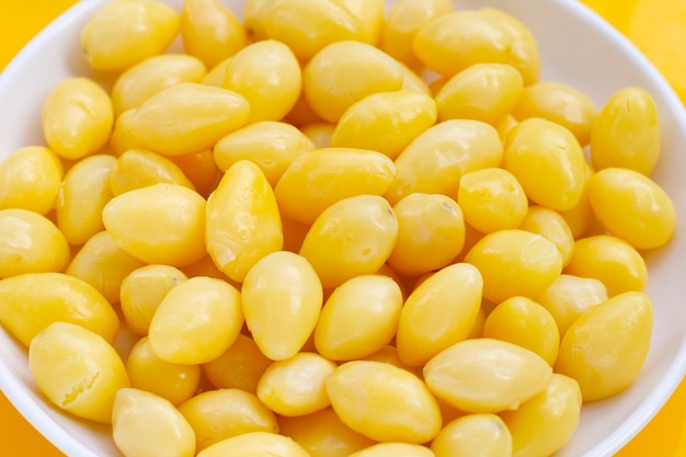 Nozes de ginkgo cozidas em fundo amarelo