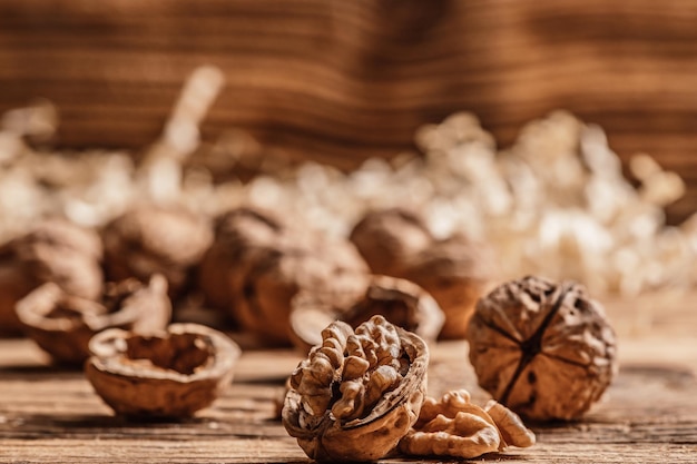 Nozes inteiras e abertas com grãos de noz em uma mesa de madeira Frutas saudáveis, salgadinhos crus orgânicos, grãos de nozes